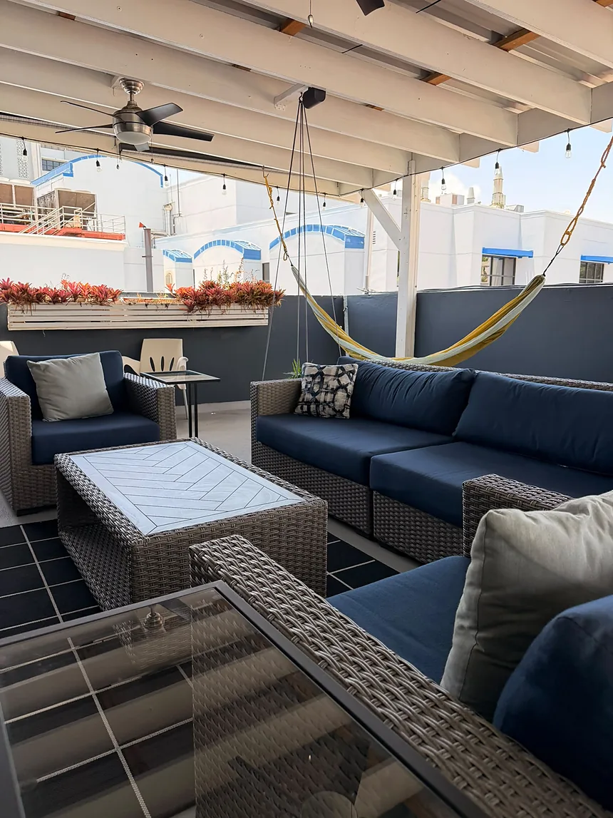 Azotea de un Airbnb con sofás azules, hamaca y mesa de centro, limpia y lista para los huéspedes