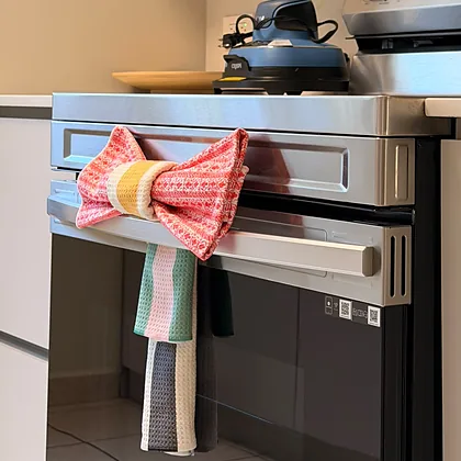 Paño de cocina doblado en forma de lazo sobre la puerta del horno